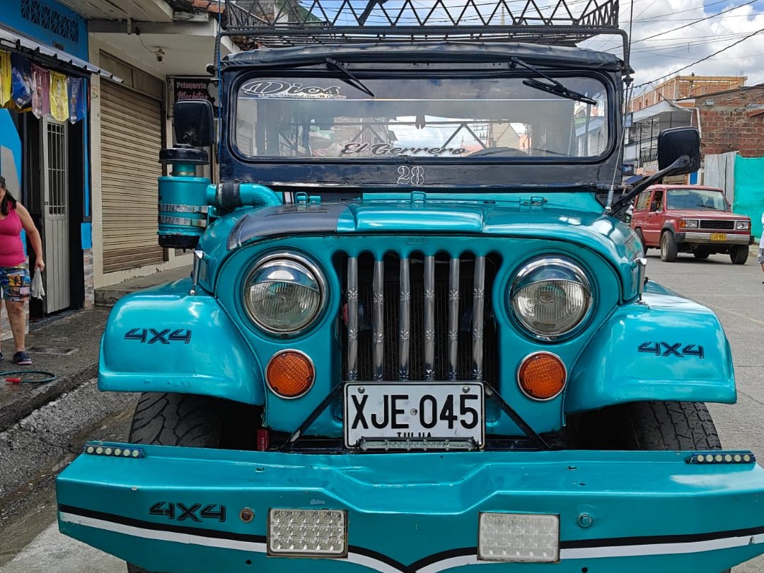 Campero Willys de la empresa visto de frente en la calle del pueblo