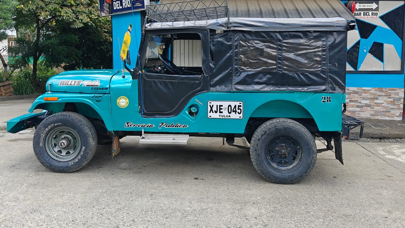 Campero Willys de la empresa, placa XJE 045, visto de perfil